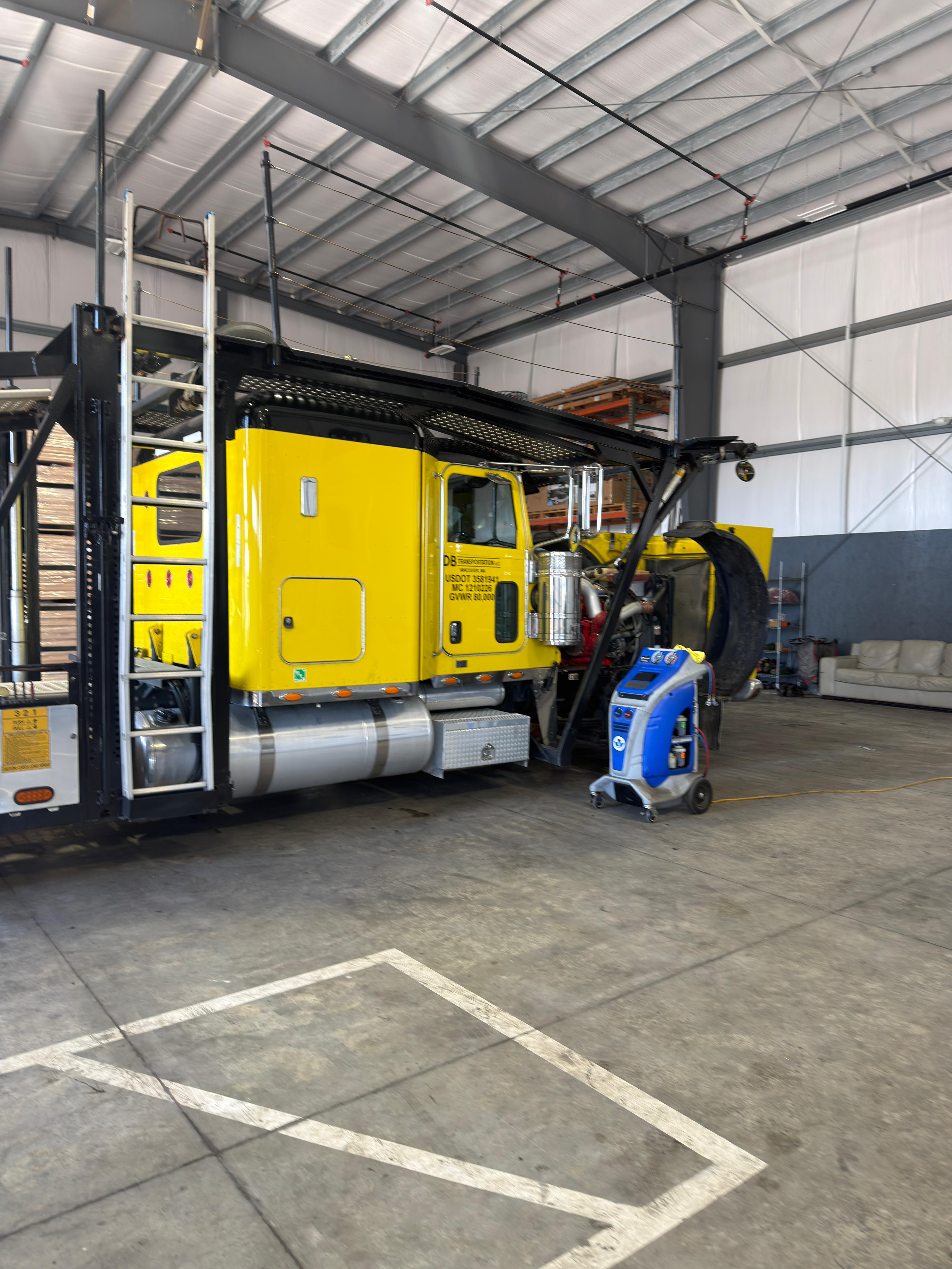 Yellow truck being serviced in the repair shop